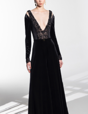 A woman is wearing a long black dress with a plunging neckline