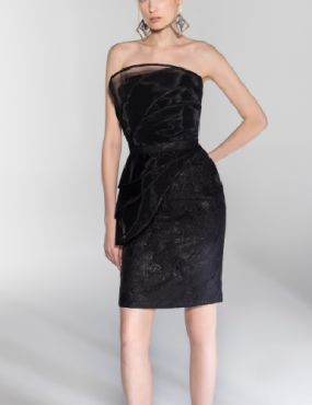 A woman is wearing a black strapless dress and earrings