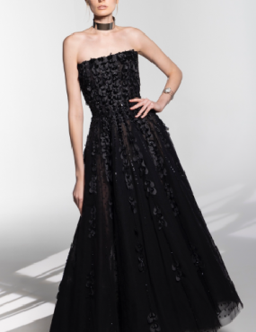 A woman is wearing a black strapless dress and a choker