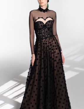 A woman is wearing a long black dress with polka dots