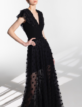 A woman in a long black dress with polka dots