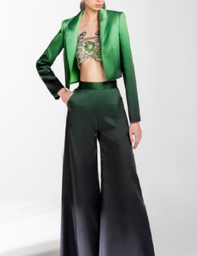 A woman is wearing a green jacket and black pants