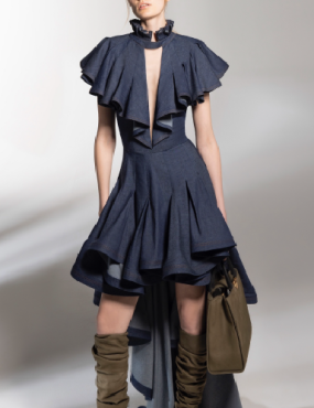 A woman is wearing a blue dress with ruffles and knee high boots