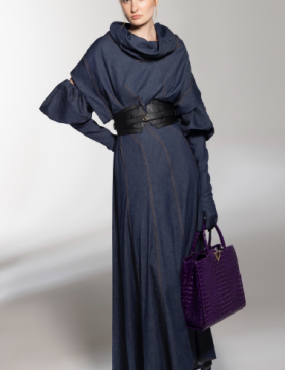 A woman in a long blue dress is holding a purple purse