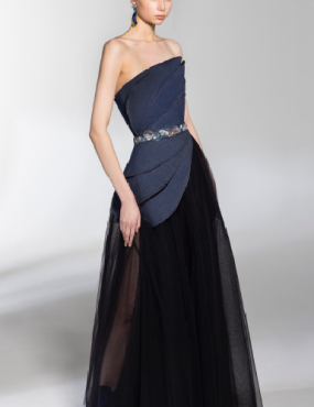 A woman is wearing a blue strapless dress and a black tulle skirt