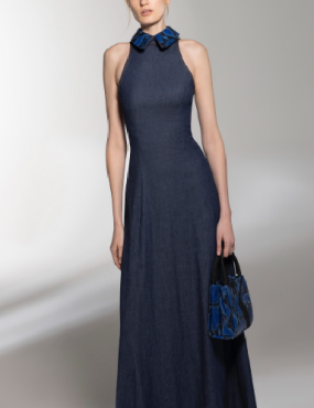 A woman in a long blue dress is holding a purse