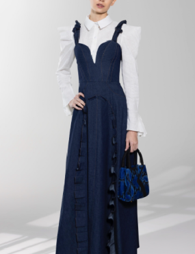 A woman is wearing a long blue dress and a white shirt