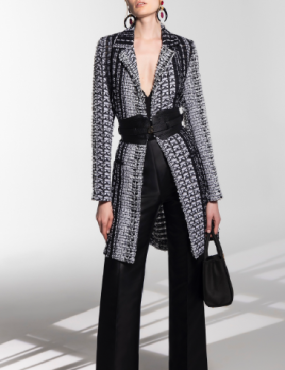 A woman is wearing a black and white coat and black pants