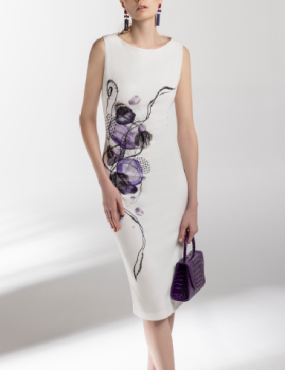 A woman is wearing a white dress with purple flowers on it
