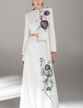 A woman is wearing a white dress with flowers on it