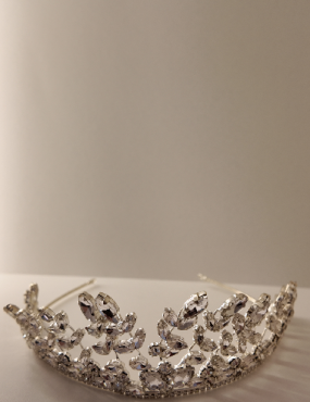 A silver tiara is sitting on a white table.