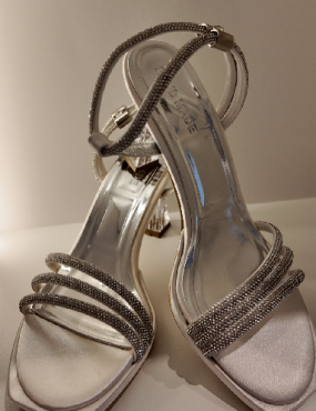 A pair of silver sandals with rhinestones on the straps
