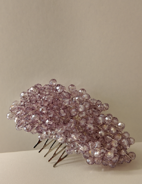 A hair comb with purple beads on it