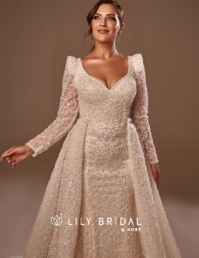 A woman is wearing a white wedding dress with long sleeves.