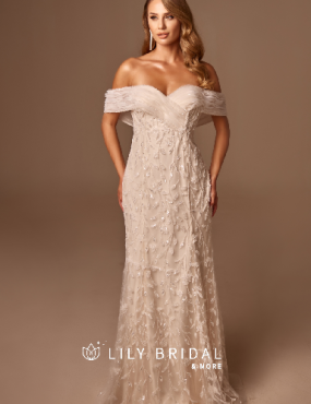 A woman is wearing a white lace off the shoulder wedding dress.