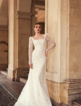 A woman in a wedding dress is standing in front of a building.