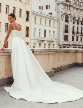 A woman in a white dress is standing on a balcony