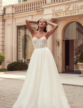 A woman in a wedding dress is standing in front of a hotel