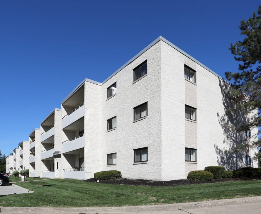 A white apartment building with a blue sky in the background