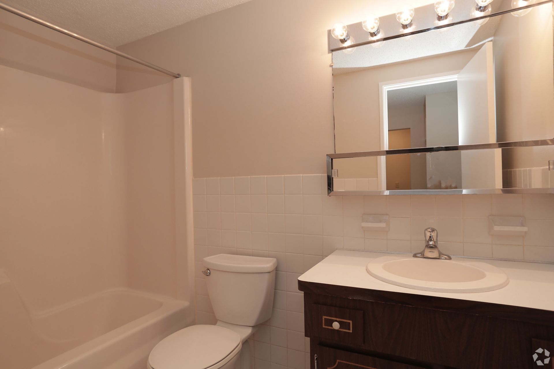 A bathroom with a toilet , sink and mirror