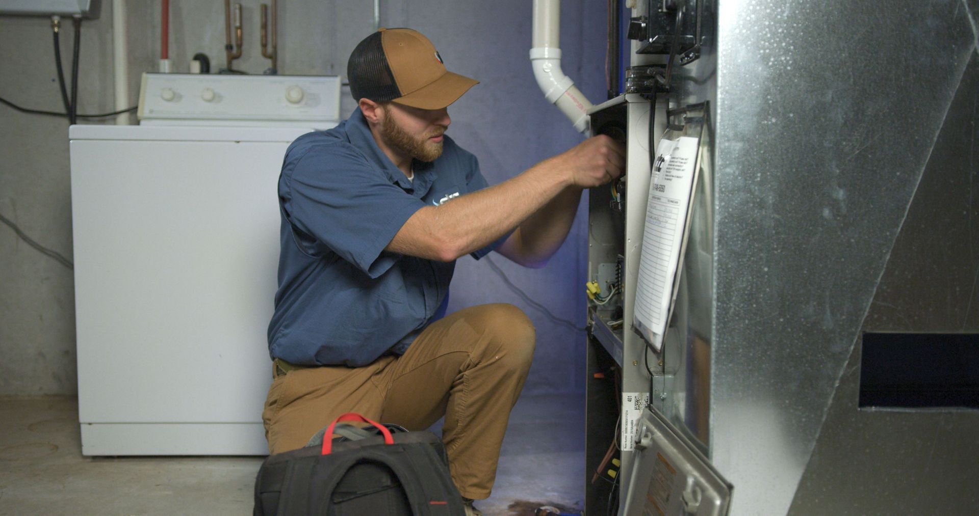 Service Technician doing routine maintenance on a furnace.
