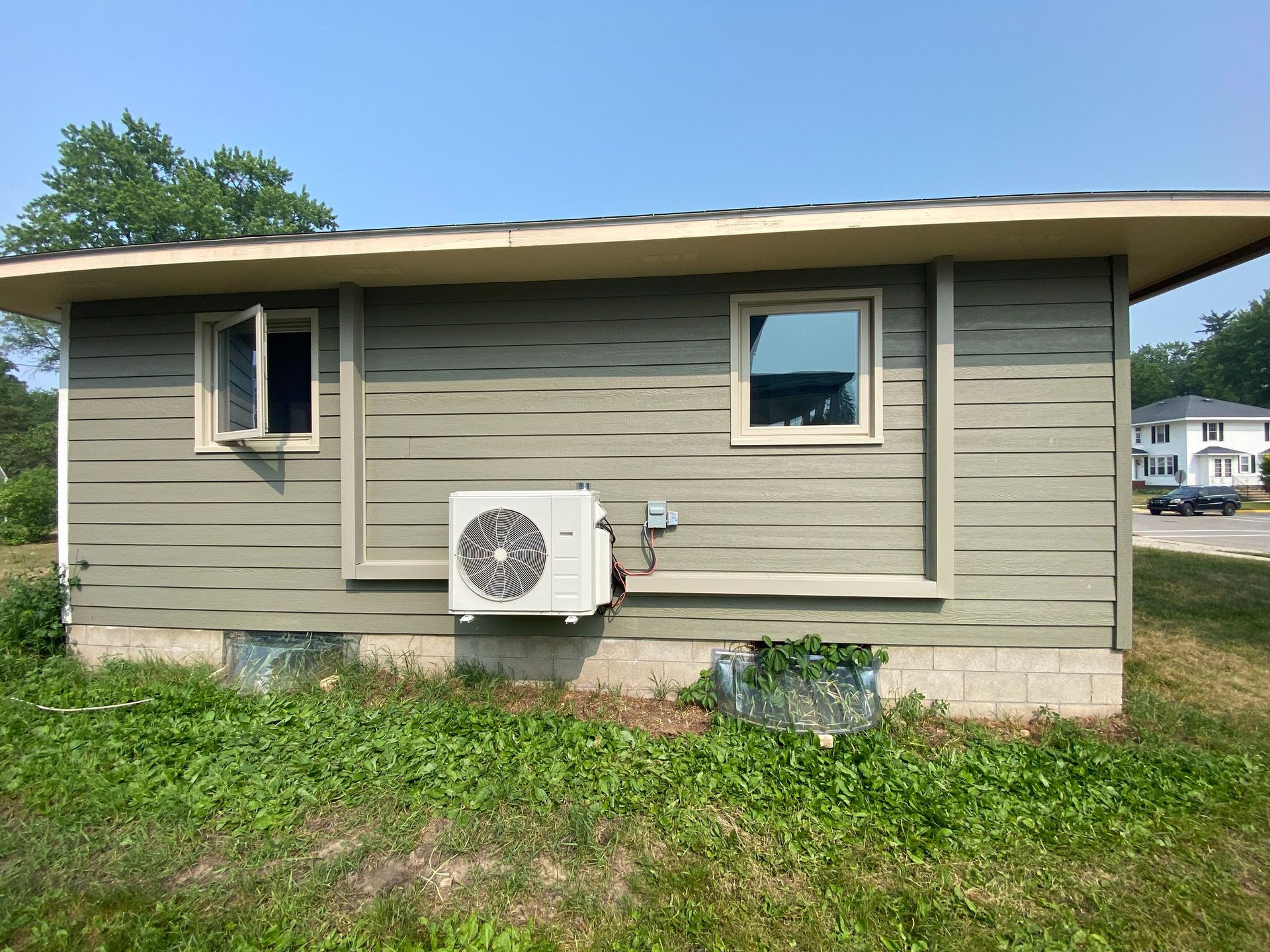 Heat pump on the outside of a green house.