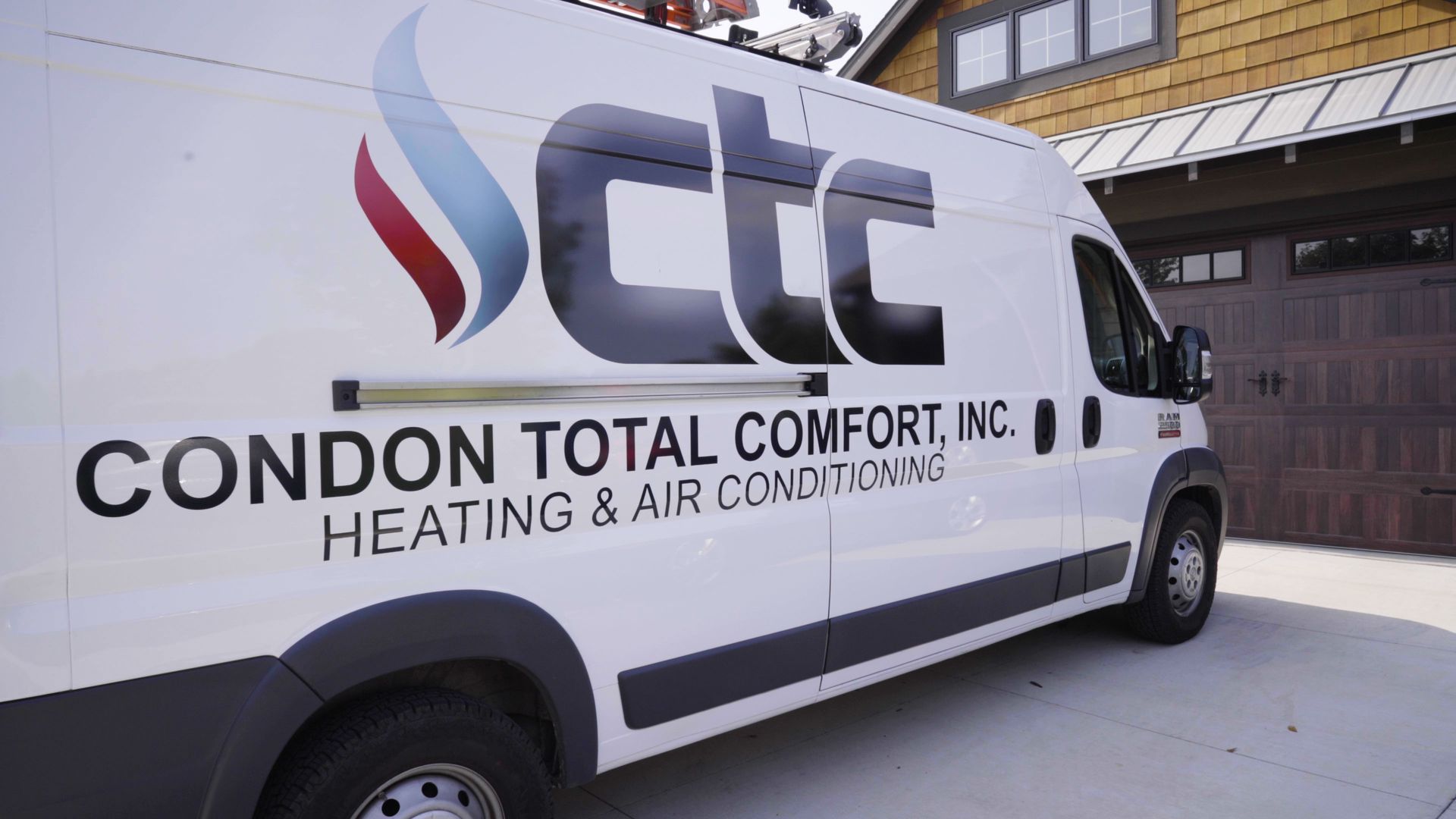 Condon Total Comfort service technician van parked in front of a house.