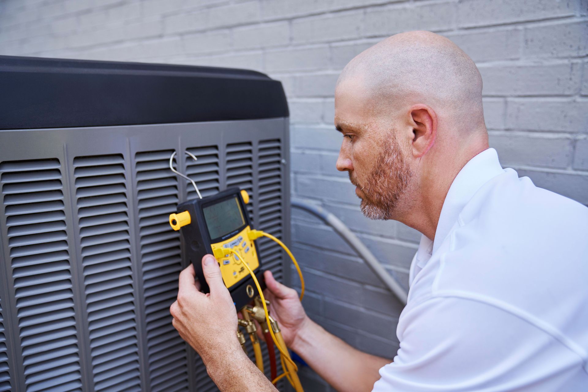 Up close of a service technician looking at his tool while running diagnostics on an air conditioner.
