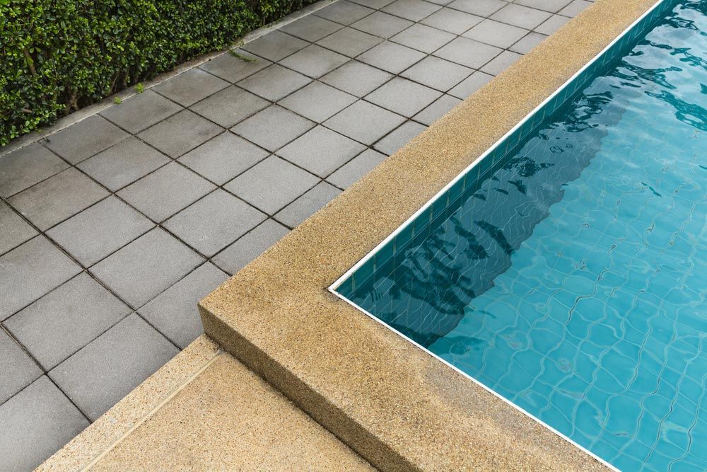 Swimming Pool With Cement Blocks Pathway And Polished Stone Floor — Professional Pool Builder in Junee, NSW