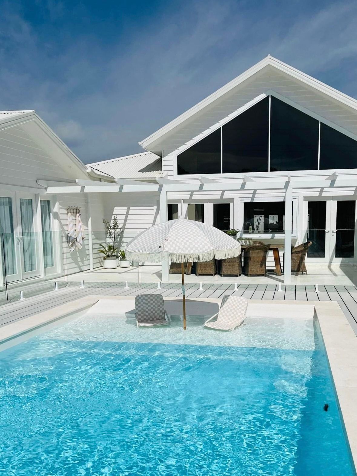 Concrete Floor Patio Area With Barbeque, Table Set, Sun Chairs And Swimming Pool — Professional Pool Builder in Wagga Wagga, NSW