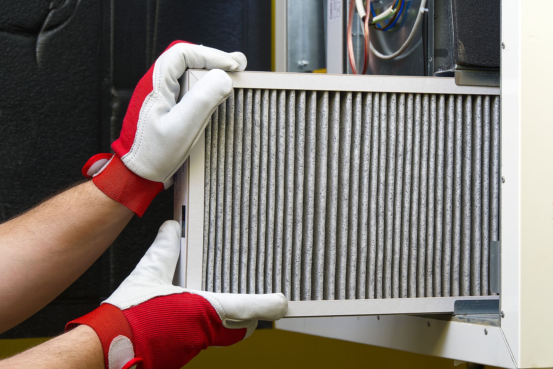 A person wearing red and white gloves is holding a filter.