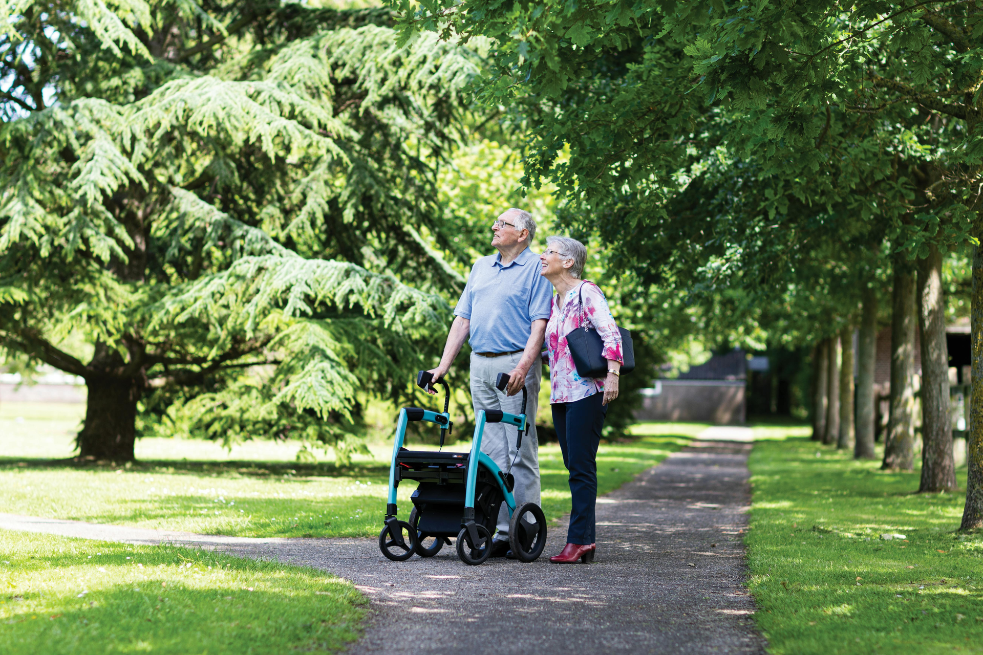 Couple utilizing a rollator to walk in the park