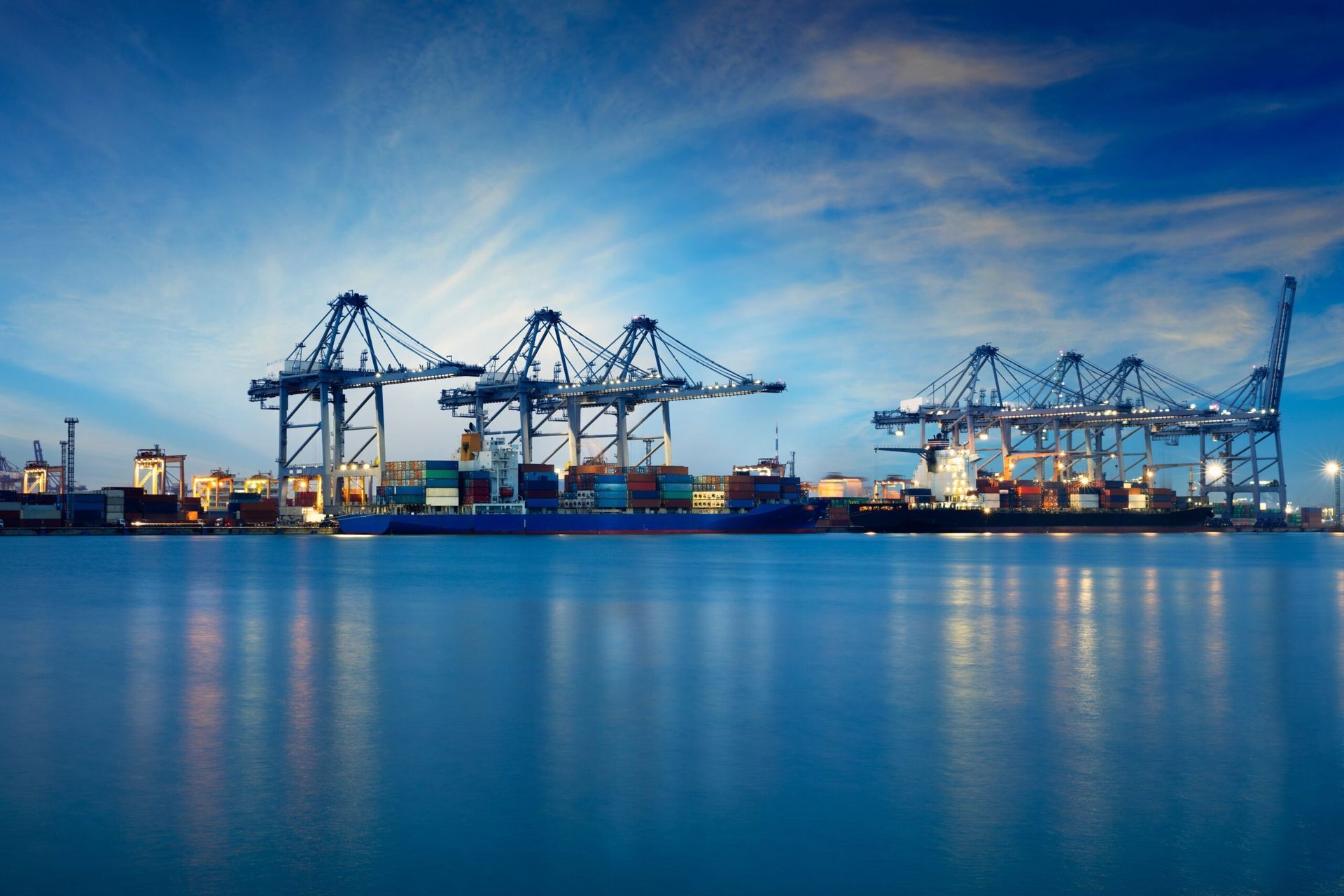 Night view of a harbor with large cranes loading cars for transporting them to California thanks to Ship A Car Hawaii