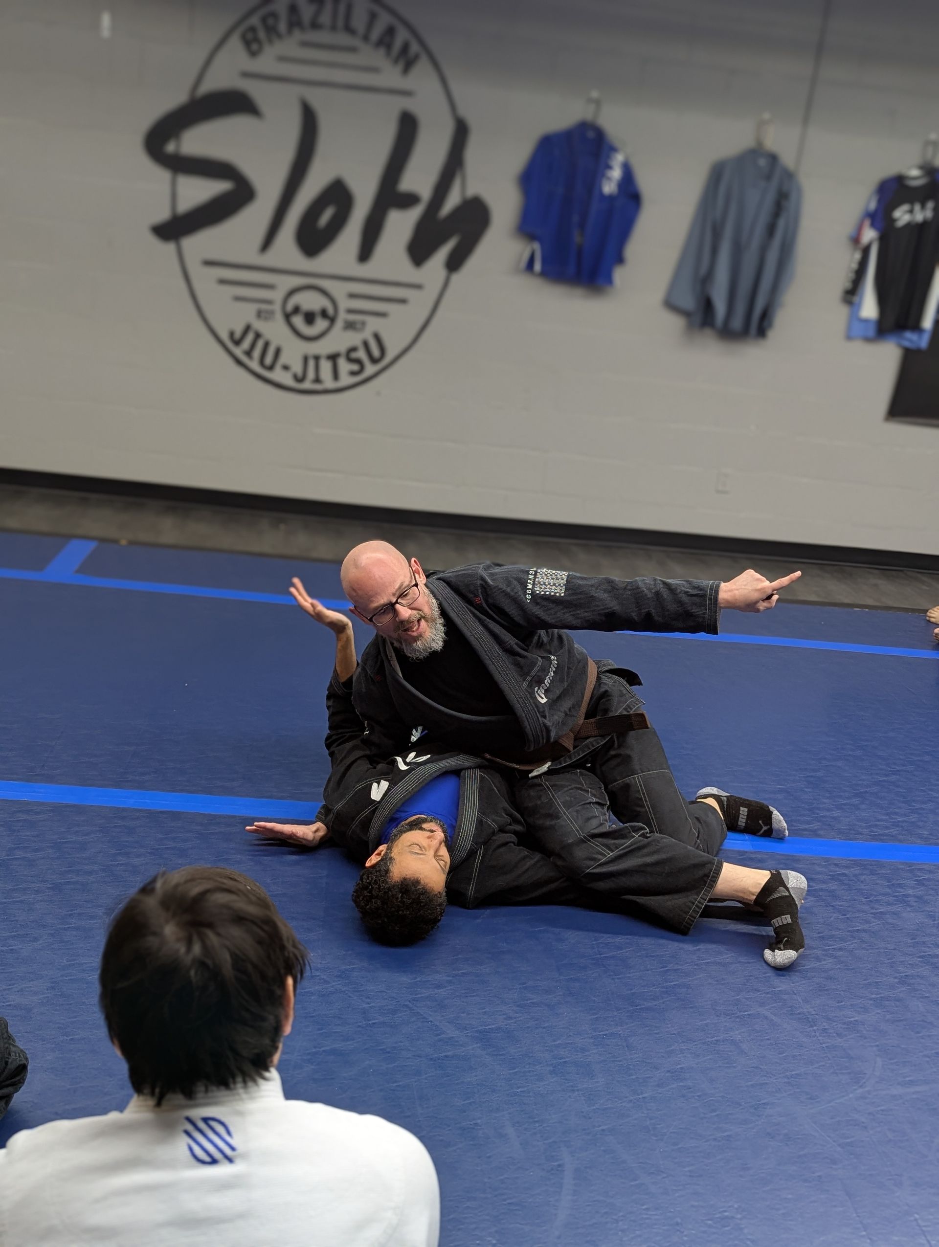 a man in a karate uniform is tying his purple belt .