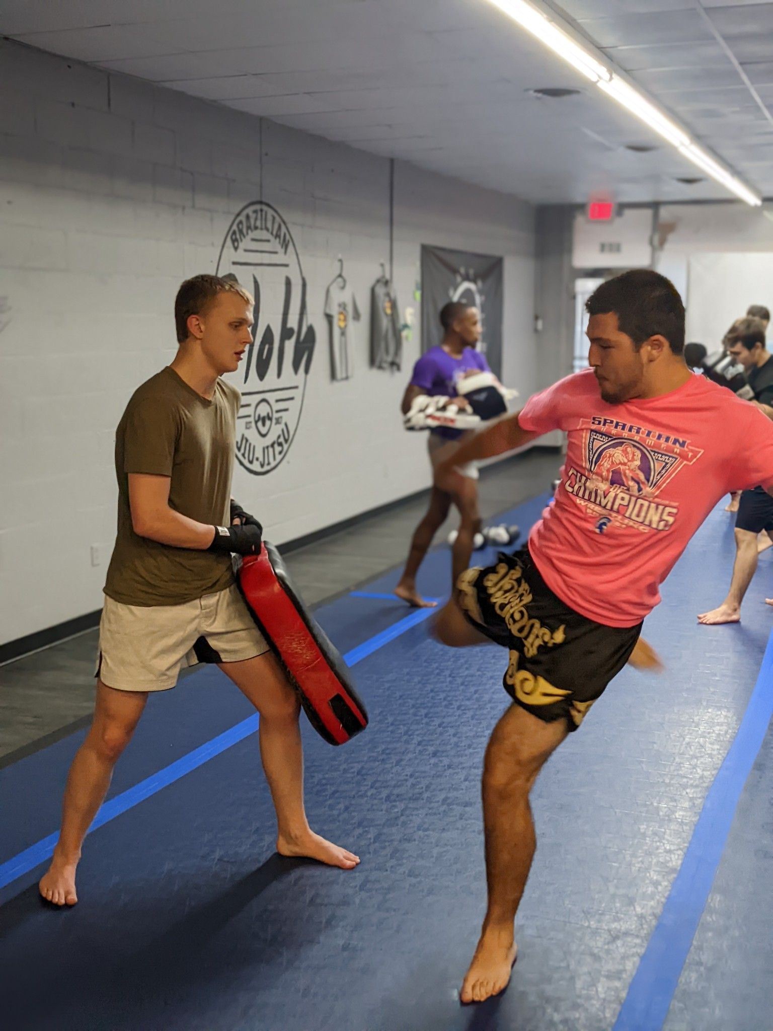 Two men wearing red boxing gloves are fighting in a ring