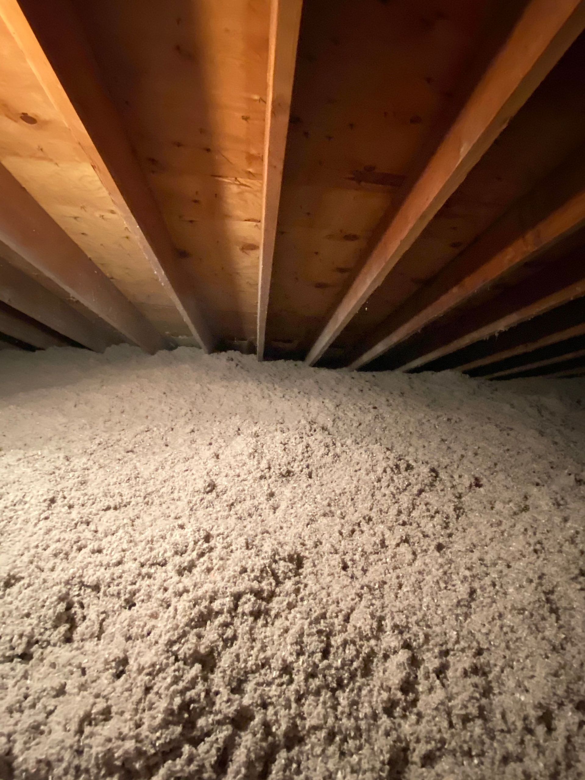 There is a lot of insulation in the attic of a house.