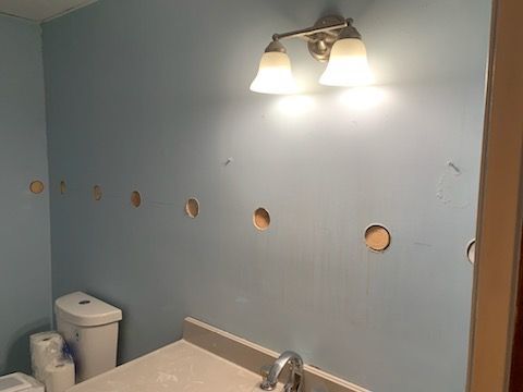 A bathroom with a sink , toilet , and light fixture.