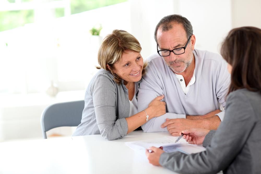 A Man and A Woman Are Sitting at A Table Talking to A Woman — Sunshine Coast Financial Advisers in Maroochydore, QLD