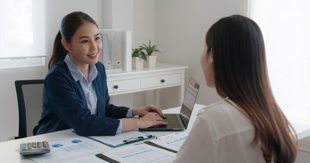 A Woman Is Sitting at A Table Talking to Another Woman — Sunshine Coast Financial Advisers in Maroochydore, QLD