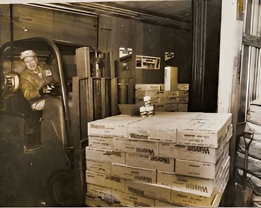 Historical photo of W.F. Fisher and Son warehouse operator using forklift to lift pallet