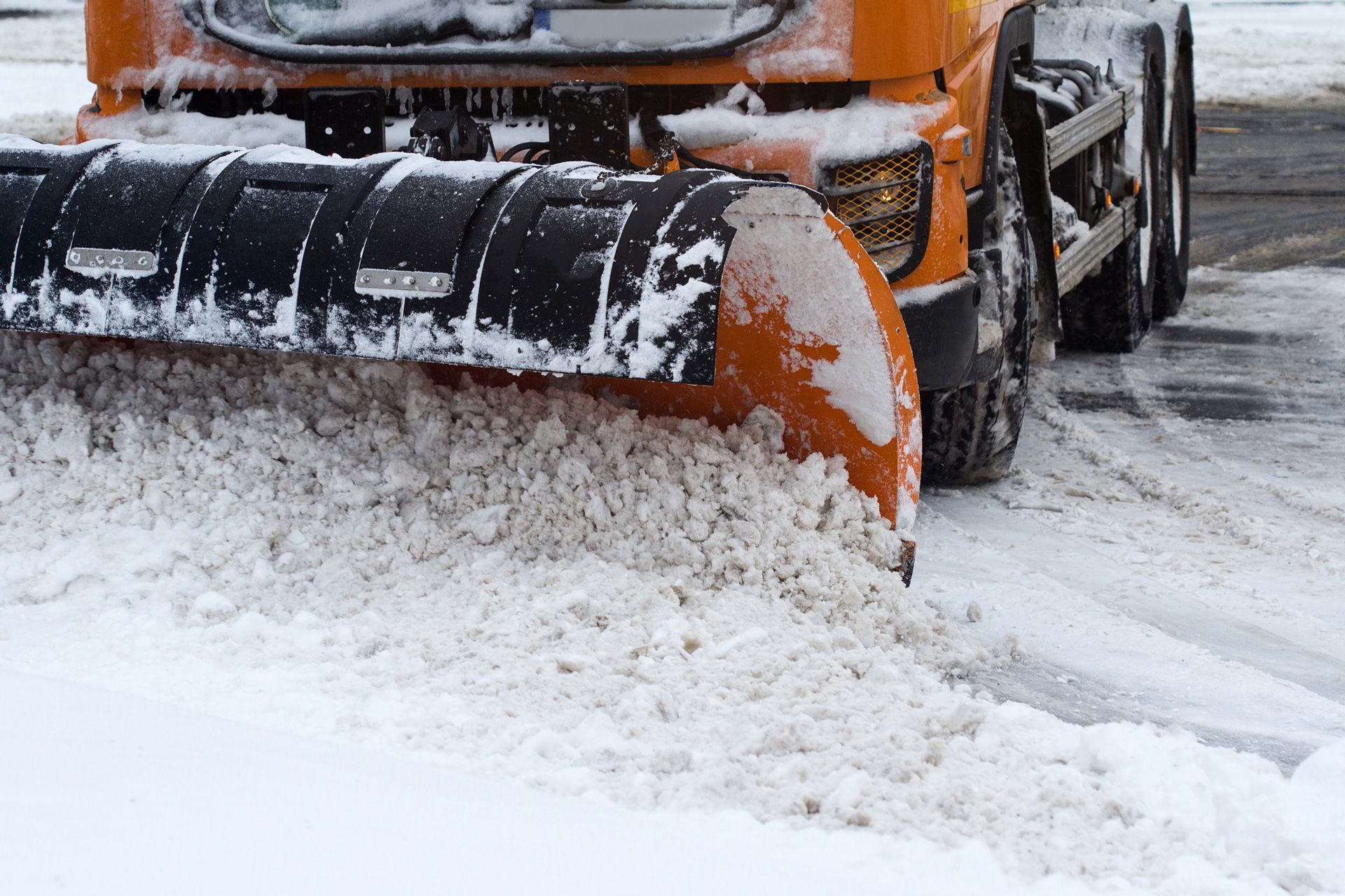 A snow plow is clearing snow from the road.