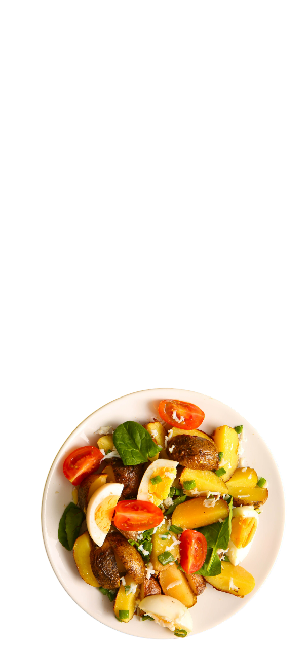 A plate of colorful salad with tomatoes, potatoes, eggs, and greens.