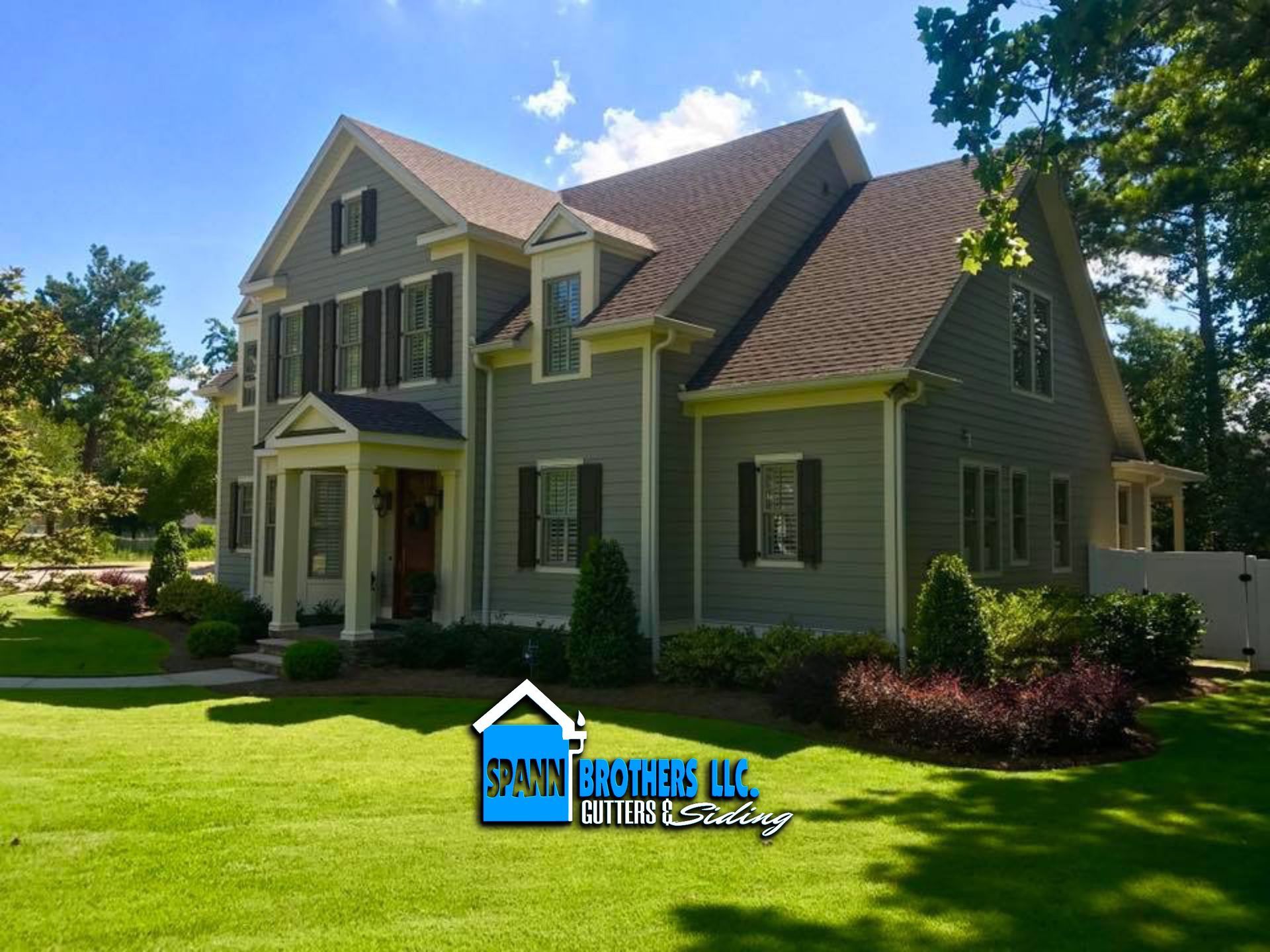 Brick building with a dark brown fence, green bush, and red vehicle in the background.