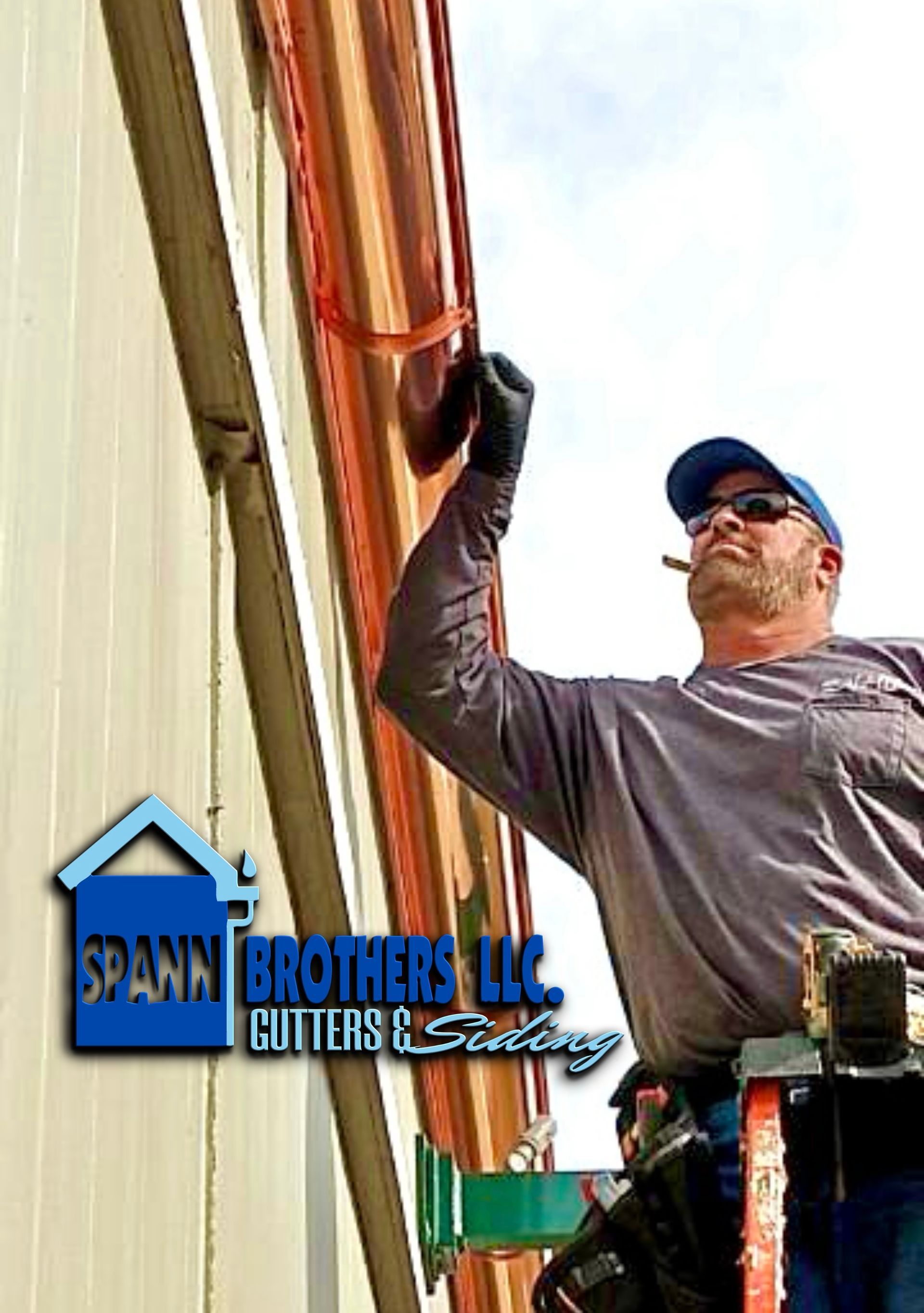 Brick building with brown gutters and windows, small bushes and walkway.