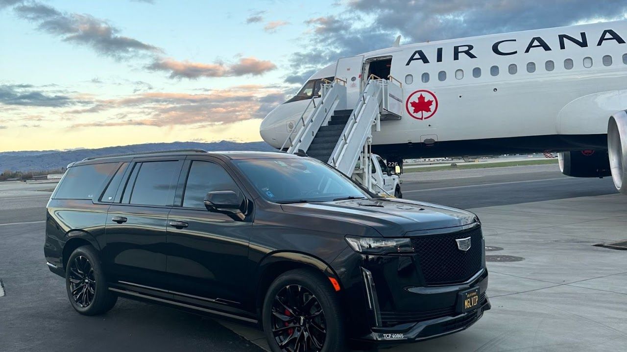 A black suv is parked in front of an air canada plane.