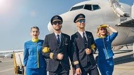 A group of pilots and flight attendants are standing in front of an airplane.