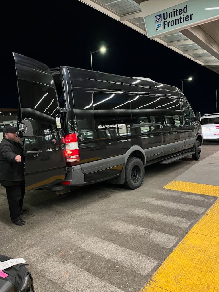 A black suv is parked in front of an air canada plane.