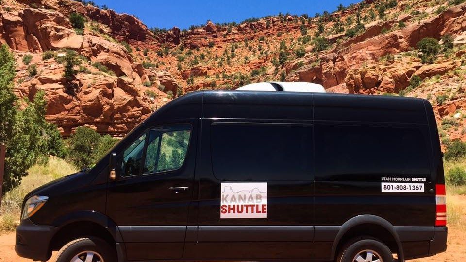 A black van with the word shuttle on the side