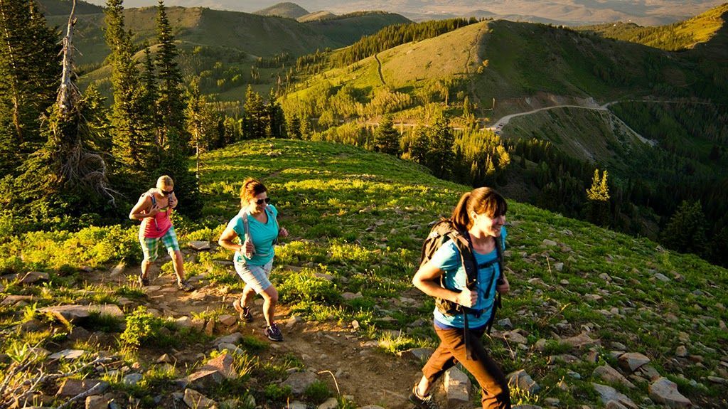 A group of people are hiking up a hill in the mountains.