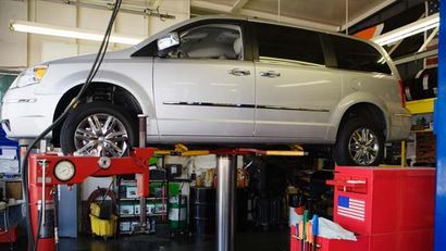 Minivan on a Lift in Shop — Auto Maintenance in McDonough, GA
